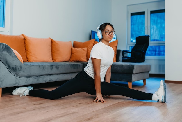 Uma mulher se alongando em seu apartamento durante o início da manhã após o treino, refletindo sua dedicação a