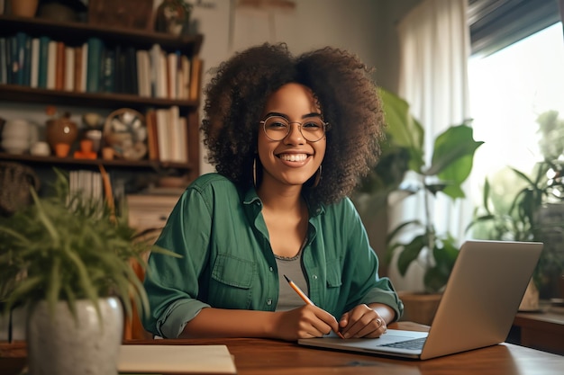 Uma mulher se senta em uma mesa com um laptop e sorri para a câmera