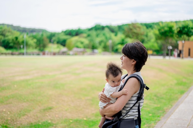 Uma mulher segura um bebê em um parque