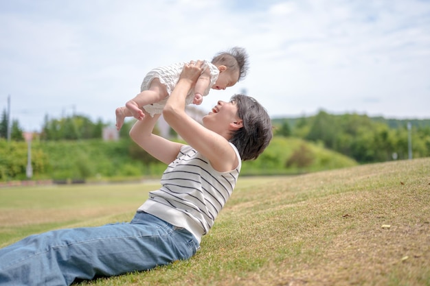 Uma mulher segura um bebê em um parque