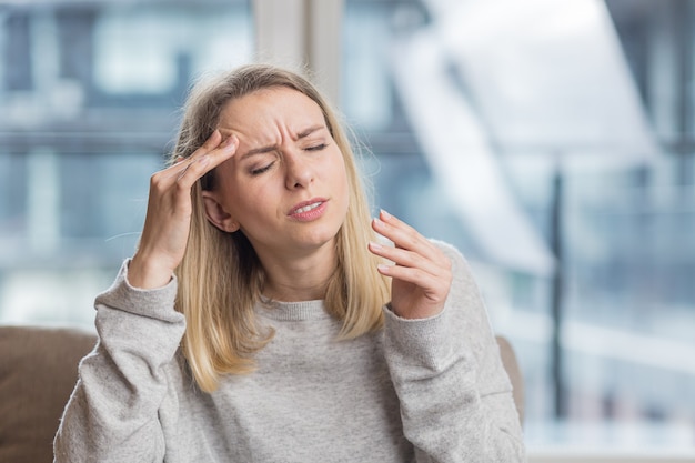 uma mulher segurando a cabeça ansiosa com uma dor de cabeça insuportável