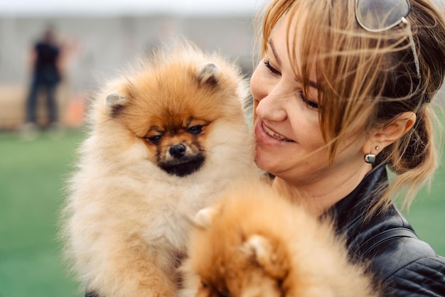 Uma mulher segurando dois cachorros em um campo