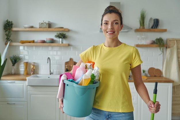 Foto uma mulher segurando um balde de roupa e um balde com suprimentos de roupa