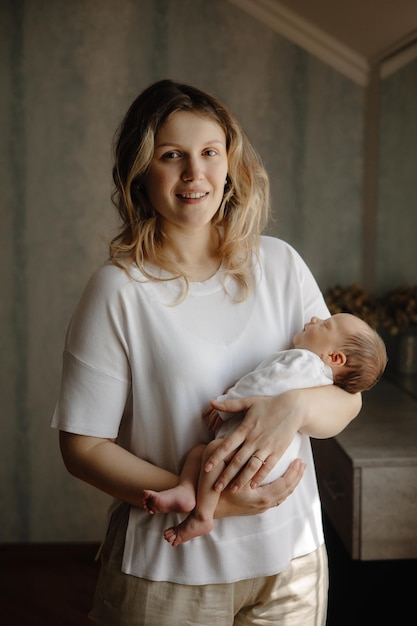 uma mulher segurando um bebê e vestindo uma camisa branca