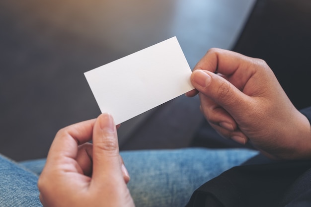 Uma mulher segurando um cartão branco vazio enquanto está sentada no escritório