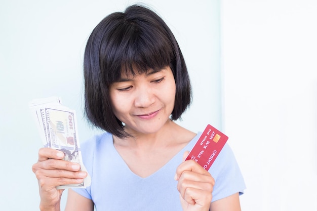 Uma mulher segurando um cartão de crédito vermelho e um cartão de crédito