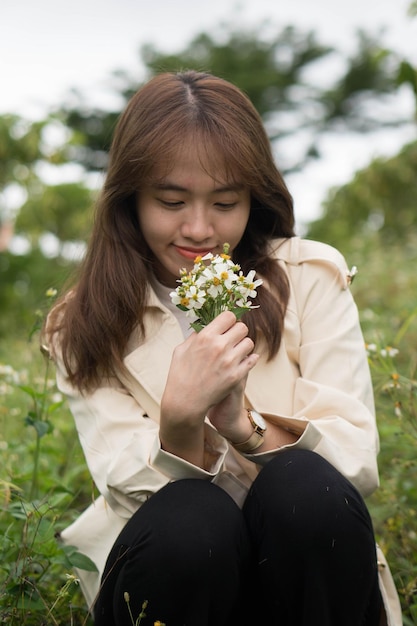 Uma mulher segurando um ramo de flores em suas mãos