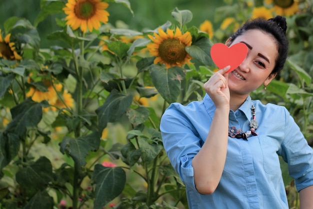 uma mulher segurando um símbolo de amor com uma expressão alegre