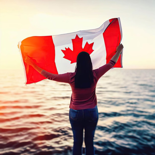 Uma mulher segurando uma bandeira canadense na frente de um corpo de água.