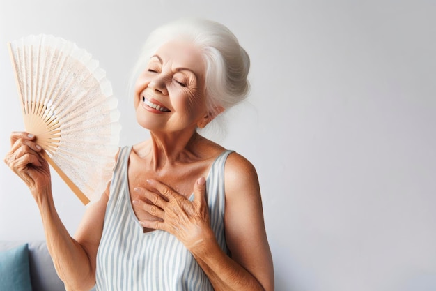 Uma mulher sênior com um ventilador acena na cara para si mesma em um fundo branco ai generativo