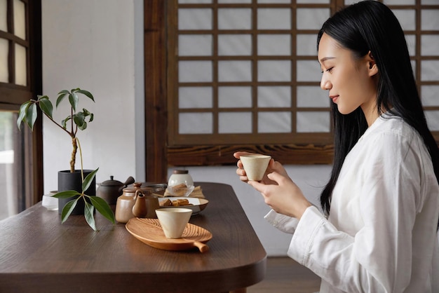 Uma mulher senta-se à mesa em uma casa japonesa.