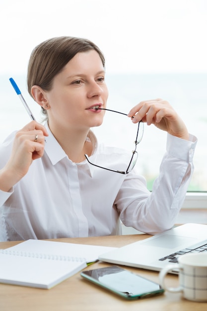 Uma mulher sonhando em um local de trabalho planejando férias