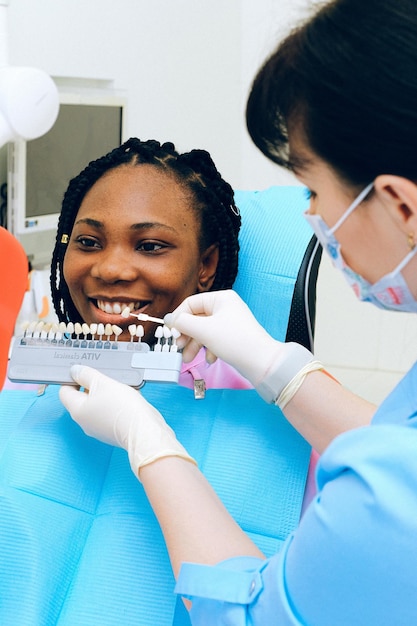 Uma mulher sorri enquanto é examinada por um dentista.