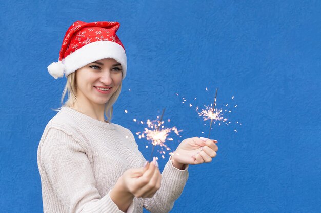Uma mulher sorridente com faíscas nas mãos Feriados e eventos Natal