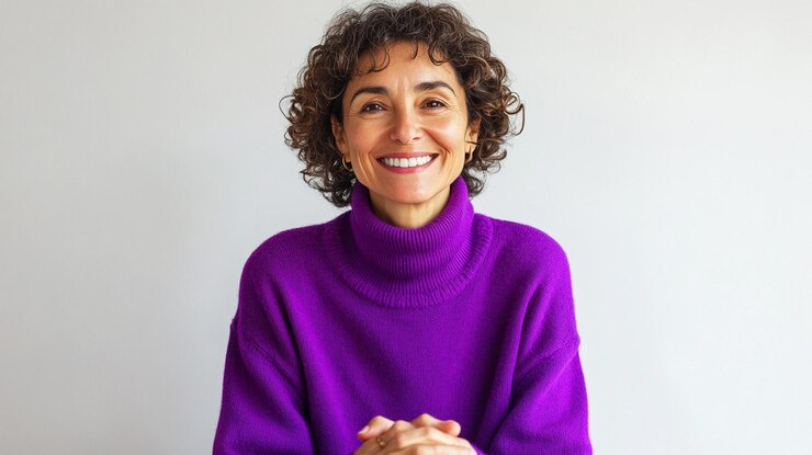Foto uma mulher sorridente com uma camisola roxa e um fundo branco
