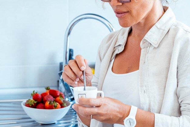 Uma mulher sozinha em casa fazendo uma pausa de café no pequeno-almoço da manhã ou pausa do dia Cafeína e pessoas estilo de vida de energia saudável Mulheres de meia-idade bonitas em atividades de lazer em ambientes fechados Cabelos rizados