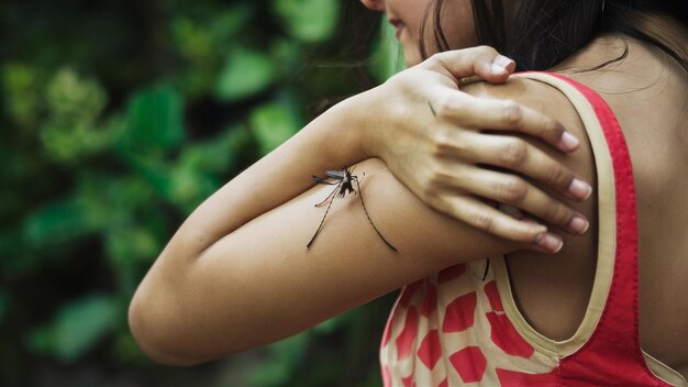 Foto uma mulher tem uma aranha no braço.