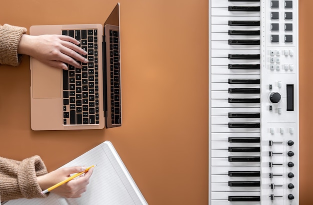 Foto uma mulher trabalha em um laptop, escreve música, cria uma música plana lay