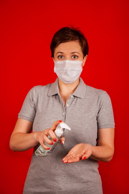 Uma mulher usa um gel, desinfetante, anti-séptico. O desinfetante para as mãos evita infecções virais e pestilentas,