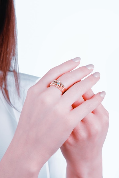 Uma mulher usando um anel com um anel de diamante azul e laranja