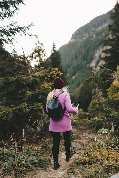 Uma mulher usando um telefone nas montanhas para ver sua localização