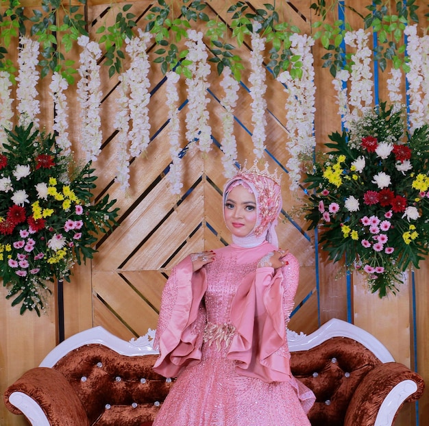 Uma mulher usando um vestido de casamento muçulmano rosa como um anjo