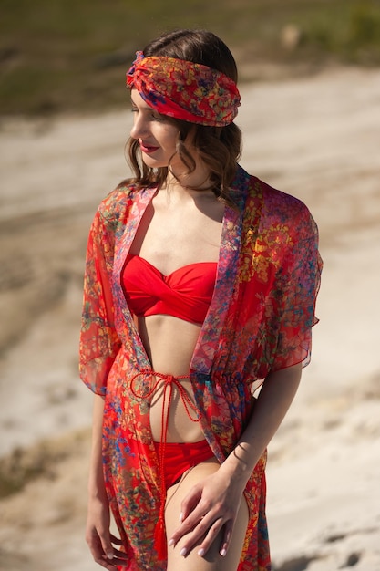 Uma mulher veste um quimono vermelho e um chapéu da marca aloha.