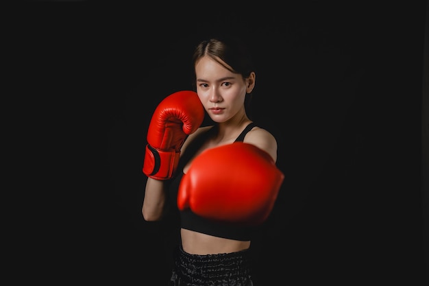 Uma mulher vestindo uma luva de boxe vermelha está posando para uma foto
