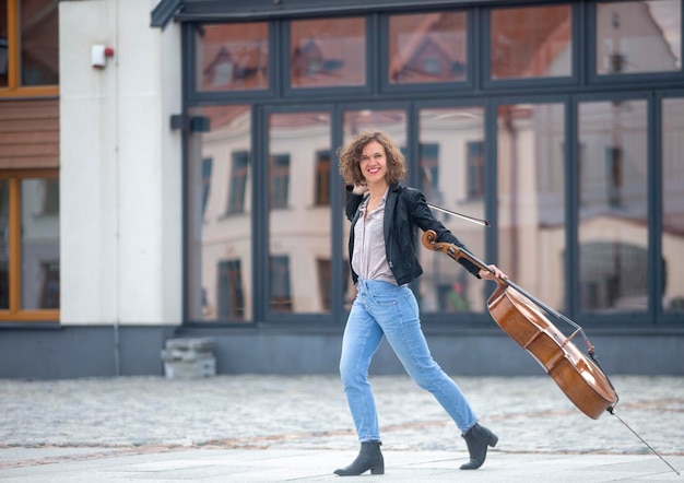 Uma músico com um violoncelo na rua.