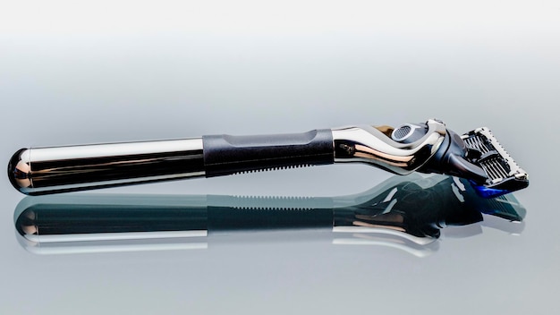 Uma navalha masculina moderna com um grande número de lâminas com superfície de vidro reflexiva. Presente para um homem de negócios. Cuidados com o corpo e a barba.