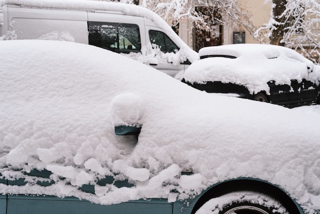 Uma nevasca repentina cobriu as ruas da cidade. Carros na neve. O inverno chegou