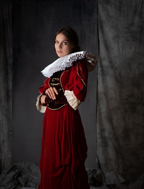 Uma nobre senhora em um luxuoso vestido vermelho estilo medieval uma jovem mulher