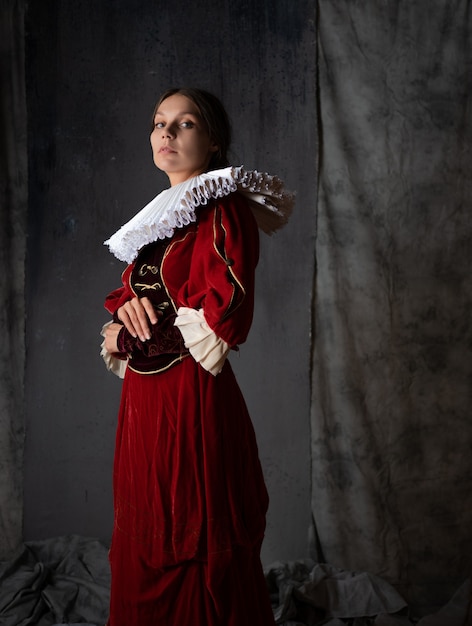 Uma nobre senhora em um luxuoso vestido vermelho estilo medieval uma jovem mulher