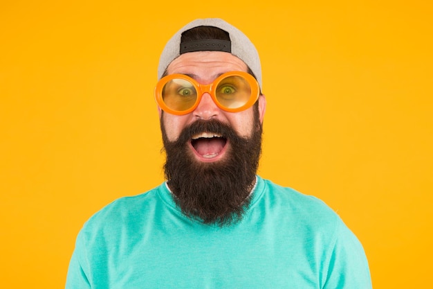 Uma noite imprudente. moda masculina de festa de verão. homem estranho com barba e bigode. homem de óculos engraçados em fundo amarelo. apenas se divirta. acessório de festa. feliz homem usa óculos no estilo hippie.