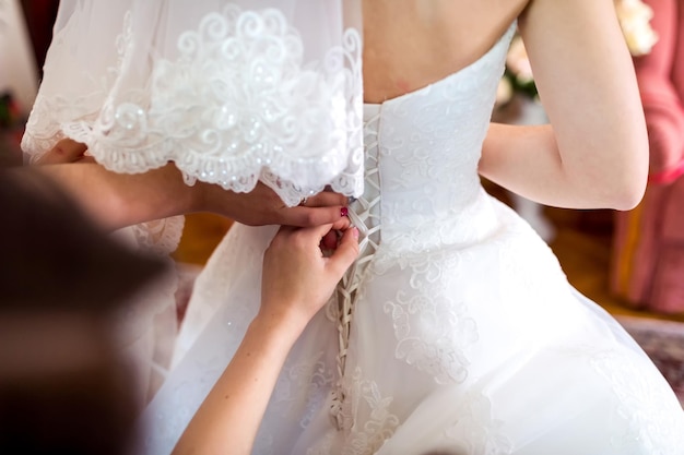 Uma noiva a preparar-se para o seu dia especial Uma noiva a vestir o seu vestido de noiva