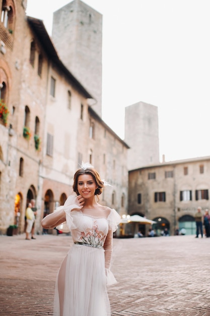 Uma noiva em um vestido branco na cidade velha de San Gimignano.