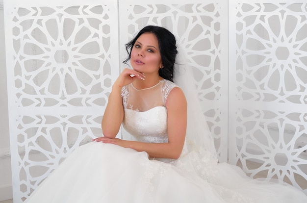 Foto uma noiva em um vestido de noiva branco em um quarto bem iluminado