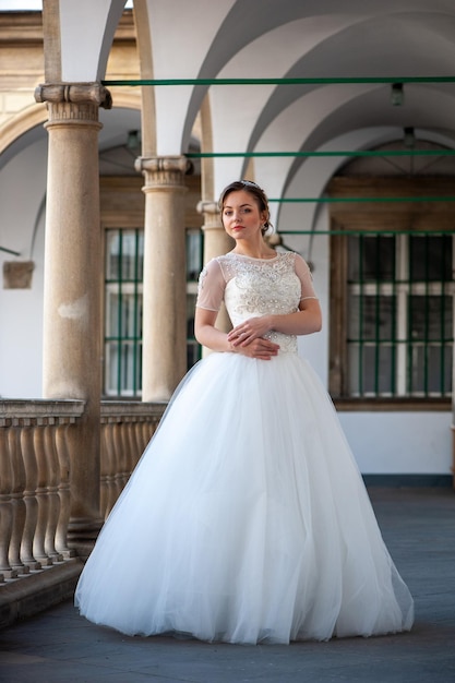 Uma noiva está em um prédio em um vestido branco