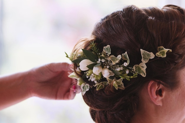 Uma noiva no salão de cabeleireiro fazendo cocar de casamento. Mãos tocando um cabelo de noiva