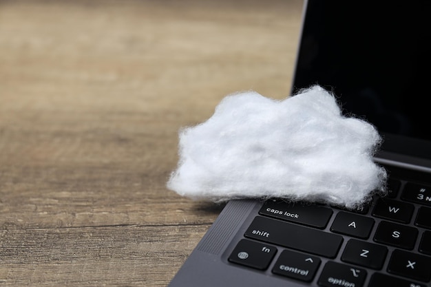 Foto uma nuvem branca feita de algodão em um lugar de teclado de laptop para texto