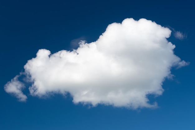 Uma nuvem cumulus branca contra um céu diurno azul escuro Uma alta resolução