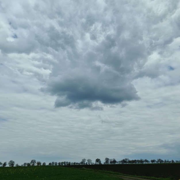 Uma nuvem que está no céu acima de um campo