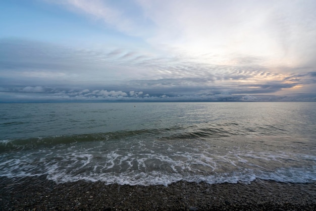 Foto uma onda entrante na costa do mar negro contra o céu do pôr-do-sol sochi território de krasnodar rússia