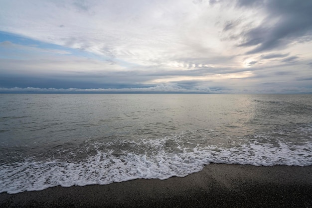 Foto uma onda entrante na costa do mar negro contra o céu do pôr-do-sol sochi território de krasnodar rússia