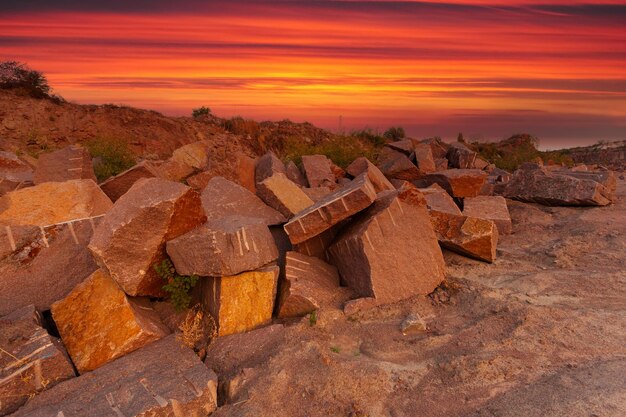 Uma paisagem desértica com rochas e pedras enormes em primeiro plano tiradas em uma pedreira de granito na Ucrânia