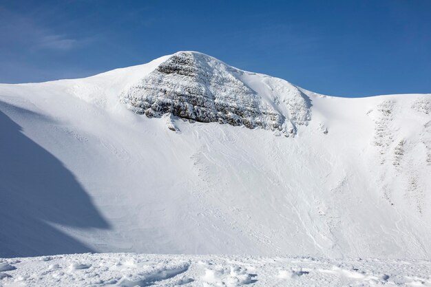 Uma paisagem rochosa coberta de neve é revelada após o poder devastador de uma avalanche