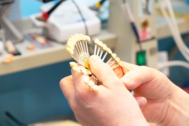 Uma paleta para determinar a cor dos dentes nas mãos de um ortopedista dental