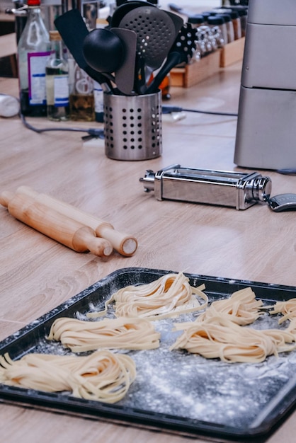 Uma panela de macarrão em um balcão com uma colher de pau ao lado.