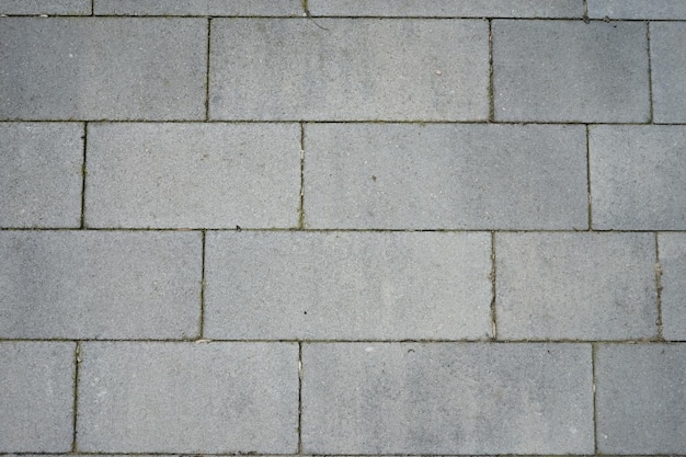 Uma parede de blocos cinza com uma espessa camada de cimento.
