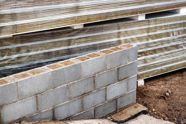 Uma parede de blocos de concreto ocos em um canteiro de obras O uso de blocos de concreto leves na construção